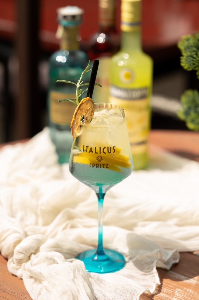 Nyári Italicus Spritz koktél asztalon, citrommal és rozmaringgal