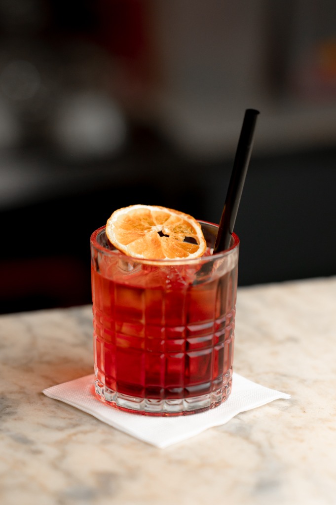 Klasszikus Negroni koktél narancskarikával jégkockán tálalva