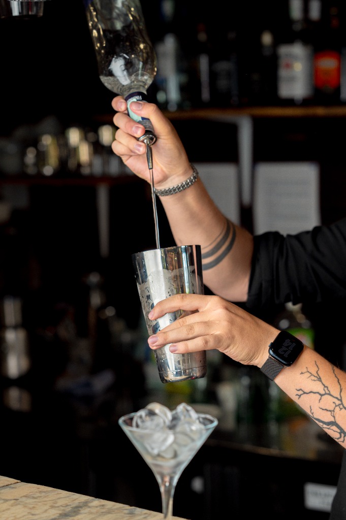 Bartender koktélt készít és italt tölt