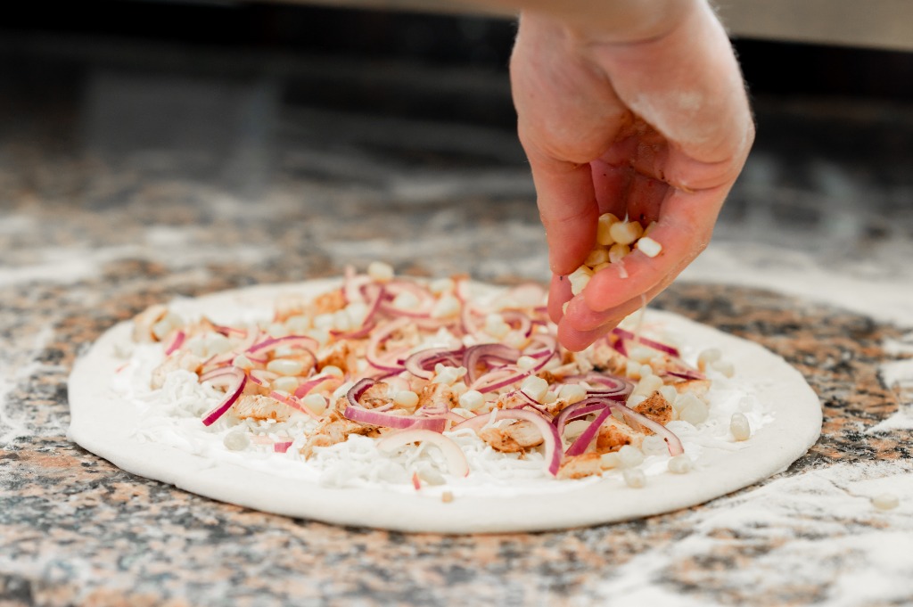Közeli felvétel a kukorica egyenletes eloszlásáról a pizzán
