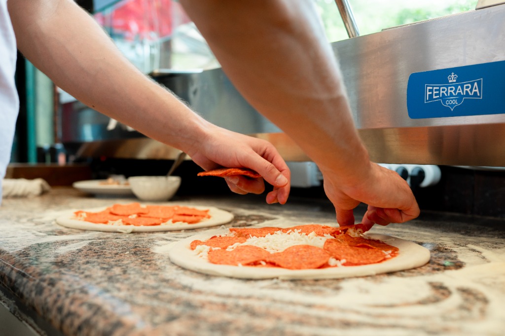 Pizza behelyezése a forró elektromos pizzakemencébe