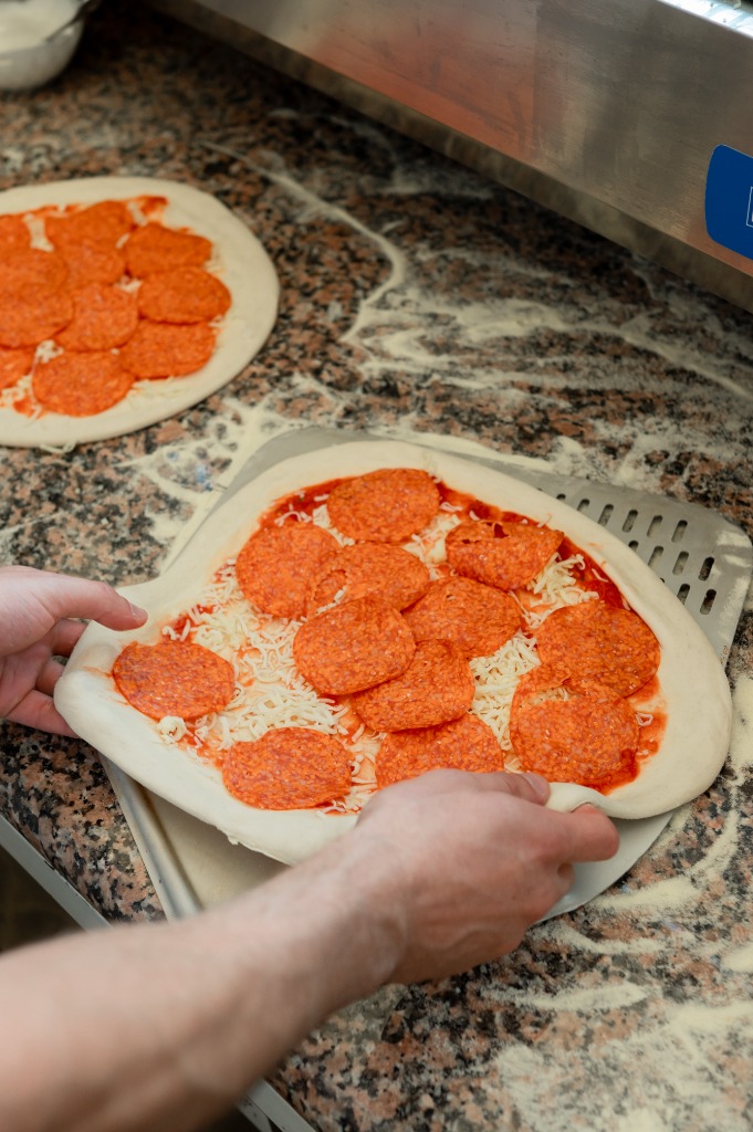 Sülő pizza a kemence belsejében, emelkedő széllel