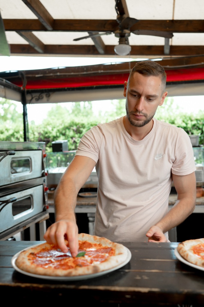 A kész pizza bemutatása friss zöld bazsalikomlevéllel