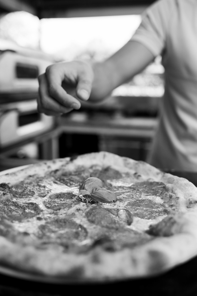 Közeli fekete-fehér felvétel a bazsalikomról a pizzán